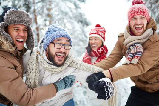 Friends enjoying laughter and connection during a winter day, reflecting warmth, balance, and emotional well-being in colder months.