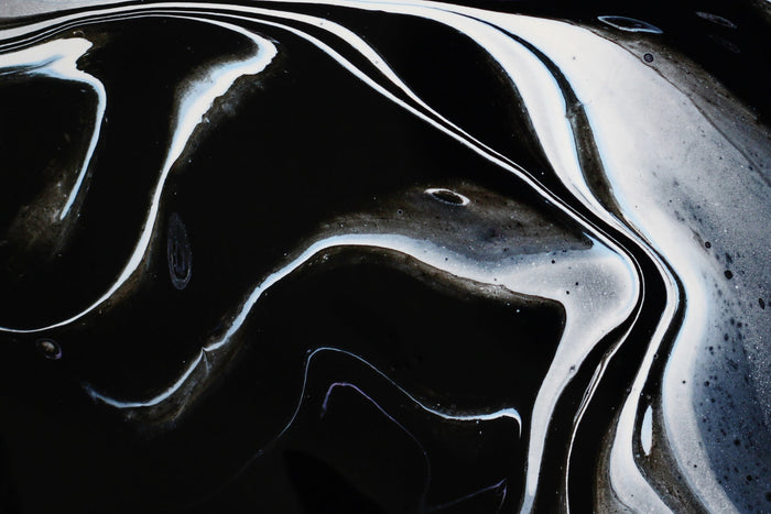 Abstract black resin texture resembling shilajit, highlighting its natural mineral-rich composition used in traditional Ayurvedic wellness practices.