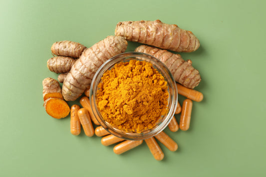 Turmeric powder in a bowl with capsules and raw roots showcasing curcumin supplements for health and wellness