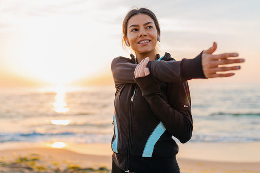 Woman stretching outdoors at sunrise, representing wellness, energy, and healthy nutrient absorption from sea moss intake.