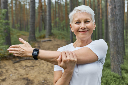 Woman stretching her arm outdoors, representing joint wellness and how turmeric curcumin may support healthy mobility, comfort, and active living.