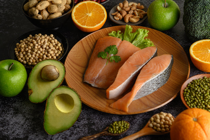 Salmon, avocado, nuts, and legumes on table showing natural zinc food sources that support immunity, metabolism, and cellular health.