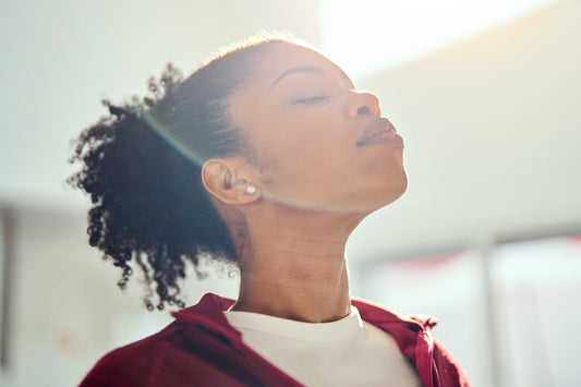 Woman practicing mindful breathing in natural light to support calm energy and balance during winter