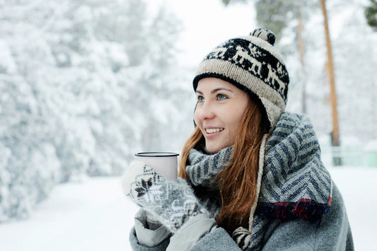 Woman enjoying a warm drink outdoors in winter, supporting comfort, resilience, and seasonal well-being