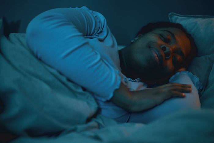 Woman sleeping peacefully at night, showing the effects of natural herbal remedies for improved sleep quality.