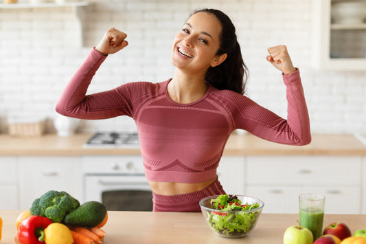 Smiling woman celebrating a healthy lifestyle with fresh vegetables, salad, and daily wellness habits that support energy and overall vitality.