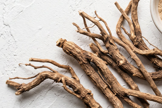 Close-up of dried Ashwagandha roots on a textured surface, symbolizing an adaptogenic herb traditionally used for calm, resilience, and wellness.