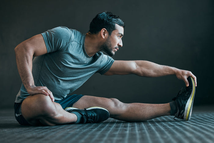 Man performing a seated stretch illustrating how turmeric and healthy daily habits can support joint flexibility and mobility