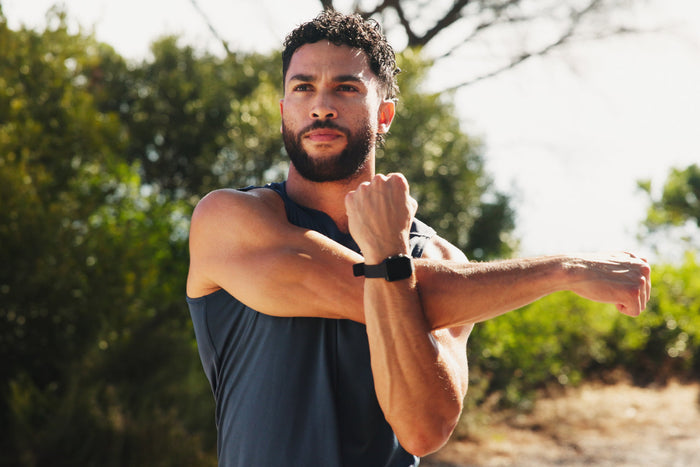 Man stretching outdoors before exercise, illustrating regular physical activity for strength, mobility, and lasting energy.