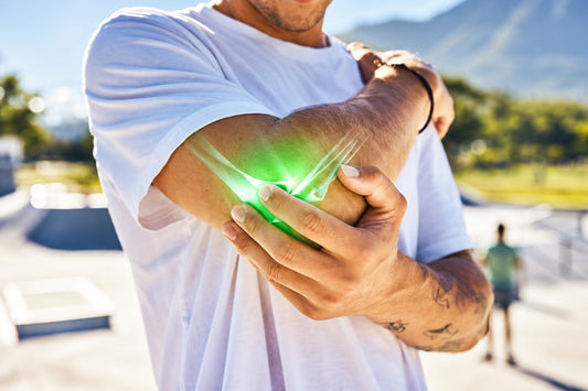 Man holding his elbow with a glowing joint illustration, representing joint discomfort and the role of turmeric curcumin in a daily joint wellness routine.