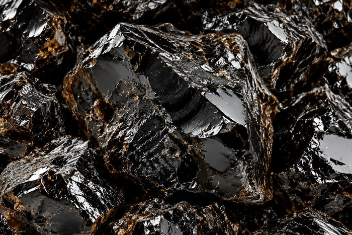 Close-up of raw black shilajit resin with natural mineral-rich texture, illustrating the traditional source of shilajit used in wellness supplements.