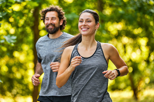 A couple jogging outdoors in a green park, representing an active lifestyle and everyday wellness alongside traditional Ayurvedic herbs such as Giloy Guduchi.